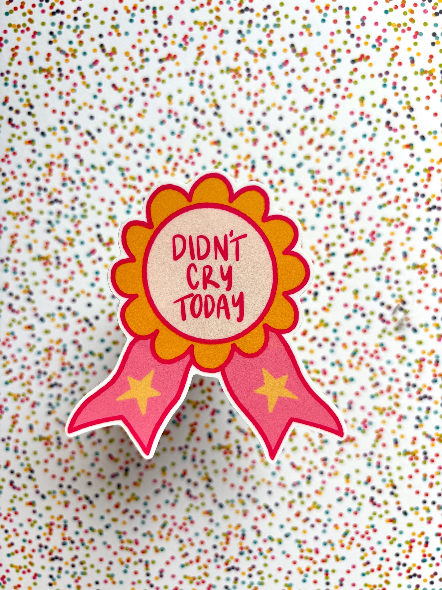 Decorative badge with 'Didn't Cry Today' text on a confetti-patterned background