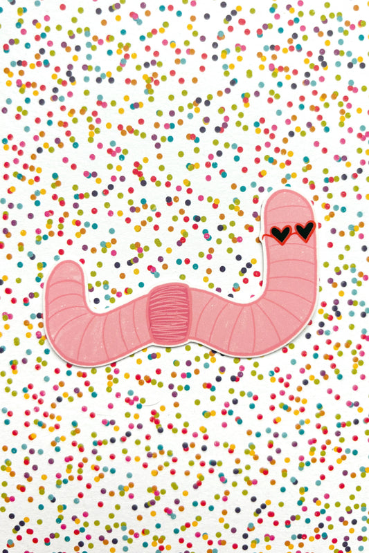 Pink worm with heart eyes on a white background with colorful confetti